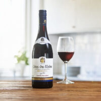 Côtes-du-Rhône Reserve på ett bord med ett vinglas